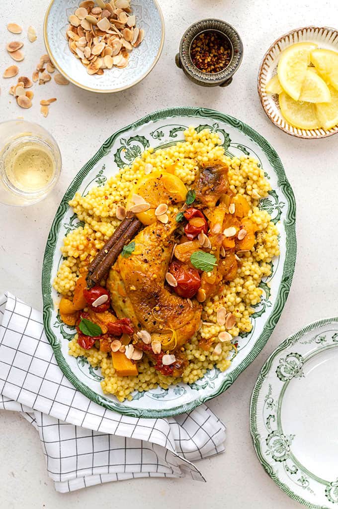 Overhead shot of platter of Moroccan chicken tagine served over giant couscous