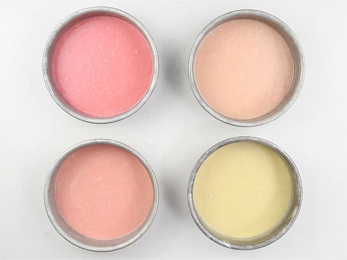 Shades of pink batter in four cake tins for ombre layer cake