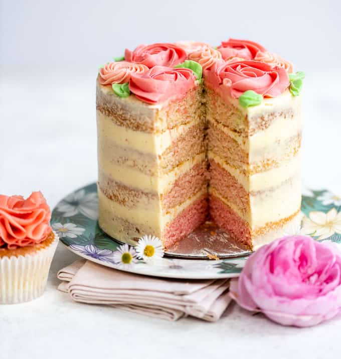 Pink ombre layer cake with slice taken out showing coloured layers