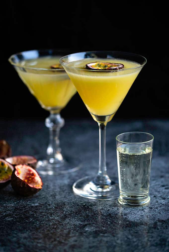 Pornstar Martini served in two glasses with passionfruit garnish and shot of Prosecco on the side