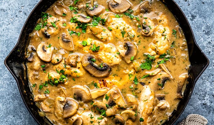 Close up on a skillet of Slimming World Chicken Stroganoff with mushrooms and parsley garnish 