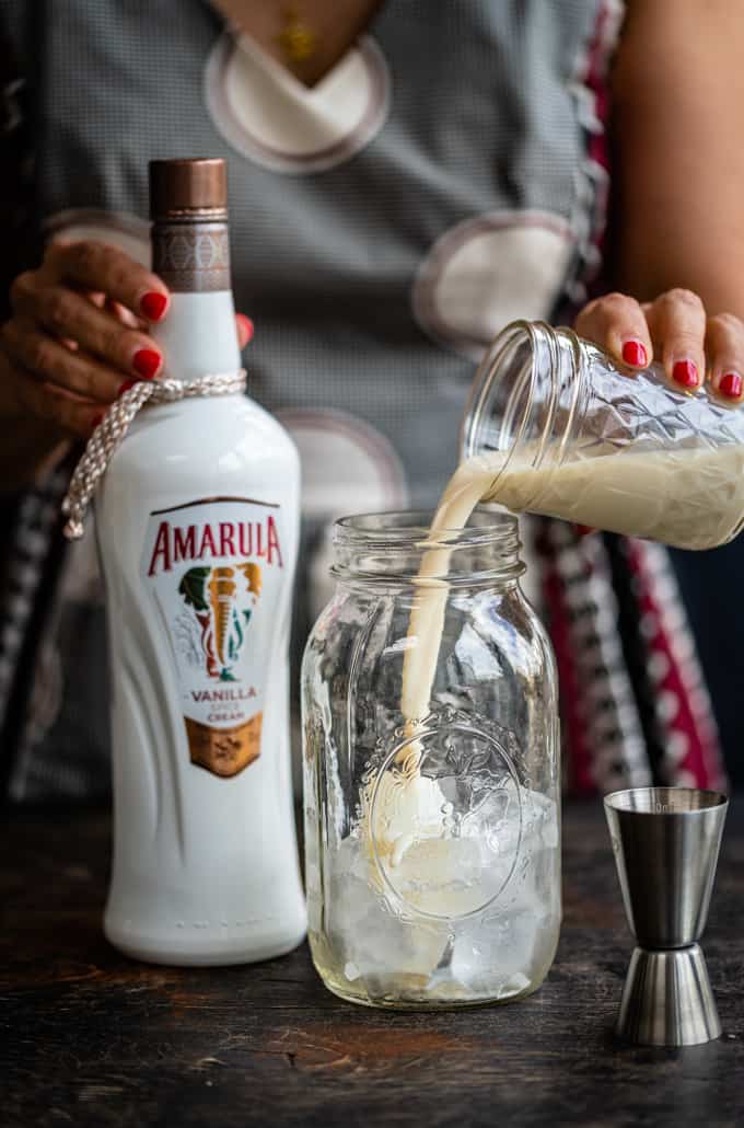 Pouring Amarula into cocktail shaker filled with ice