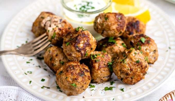 Plate of Greek meatballs (keftedes) served with Tzatziki and Greek salad
