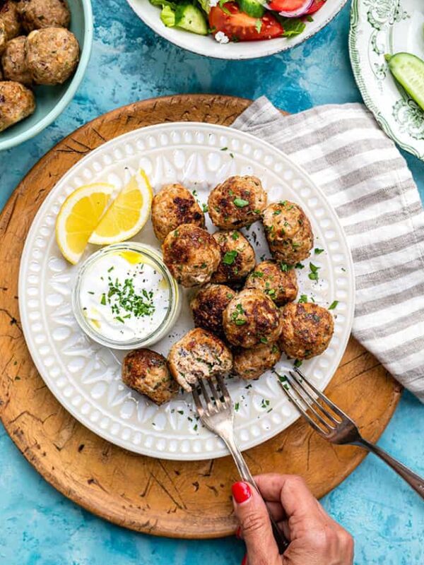 Overhead shot of a Greek turkey meatballs served with tzatziki and lemon wedges