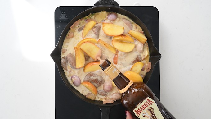 Adding Amarula to creamy sauce with apples and pork