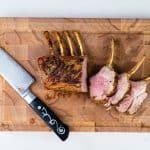 Roast rack of lamb carved into chops on a cutting board