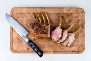 Roast rack of lamb carved into chops on a cutting board