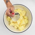 mashing boiled potatoes