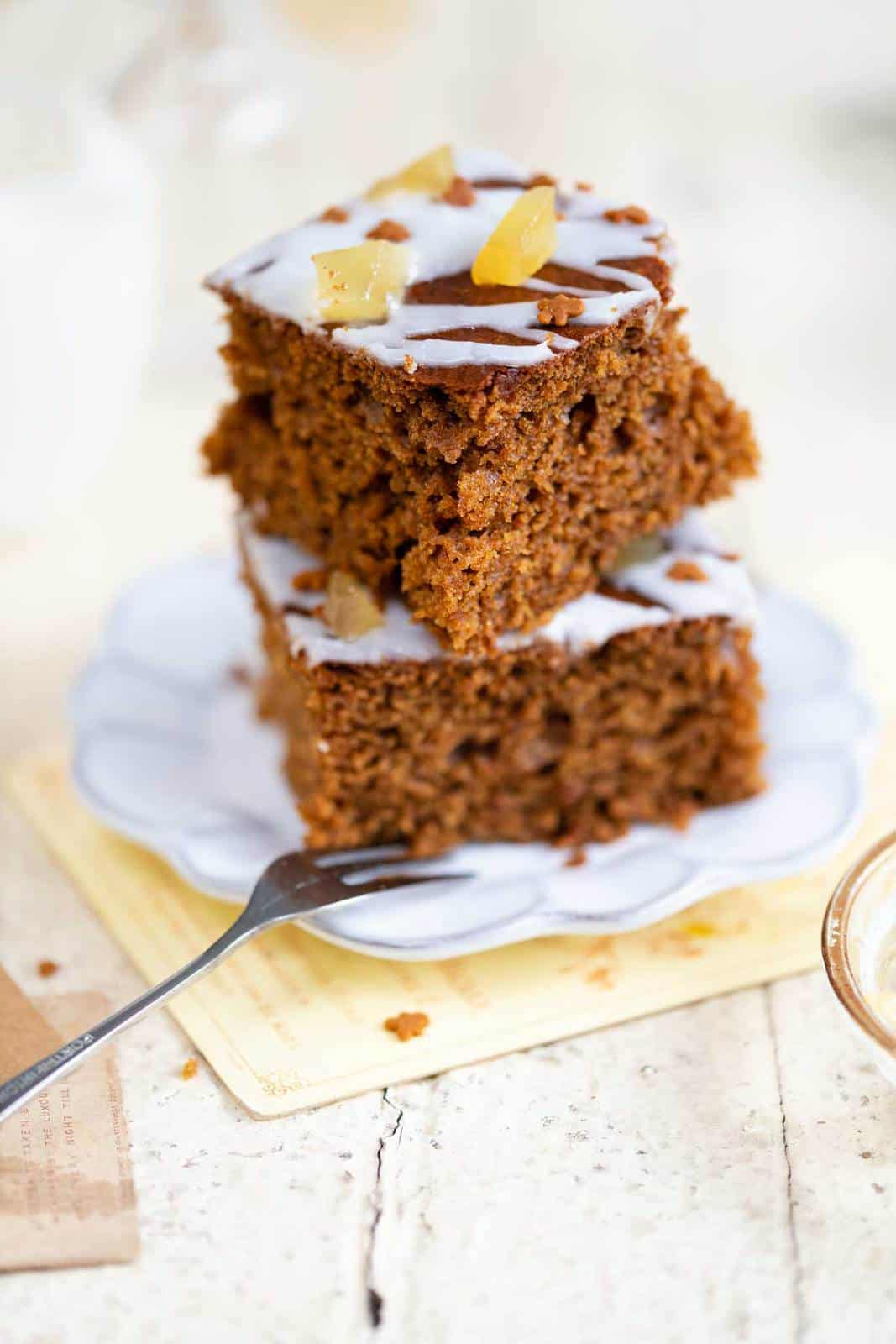 Two squares of ginger cake stacked on a small plate