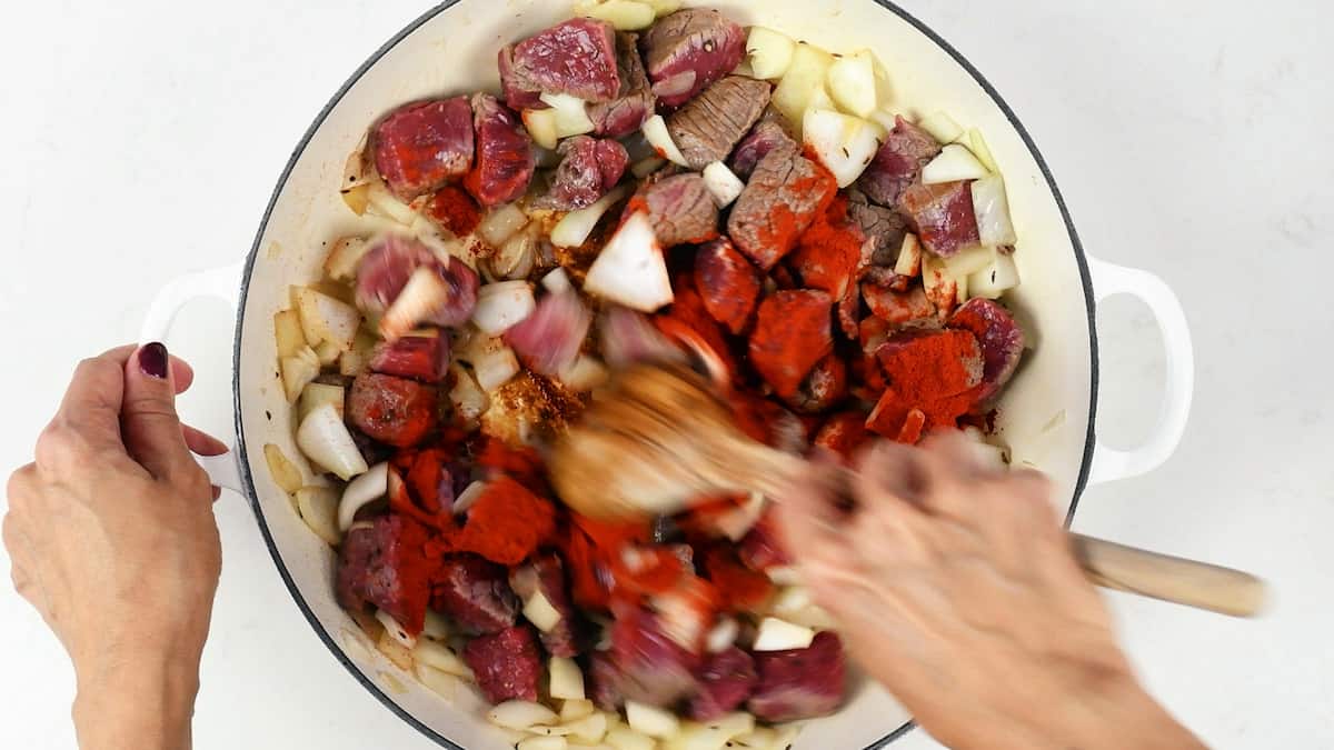 Stirring paprika into beef goulash