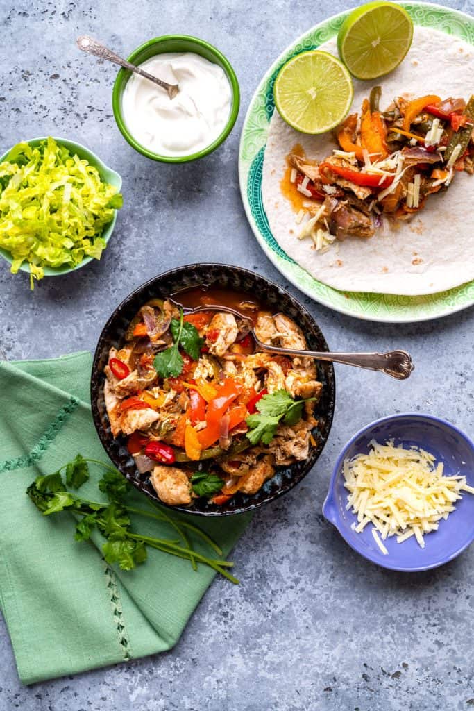 Slimming World Chicken Fajitas in a bowl with toppings on the side