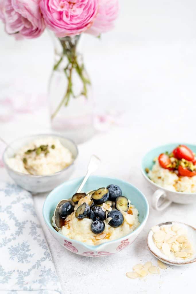 Bowls of rice pudding garnished with fresh fruit and nuts