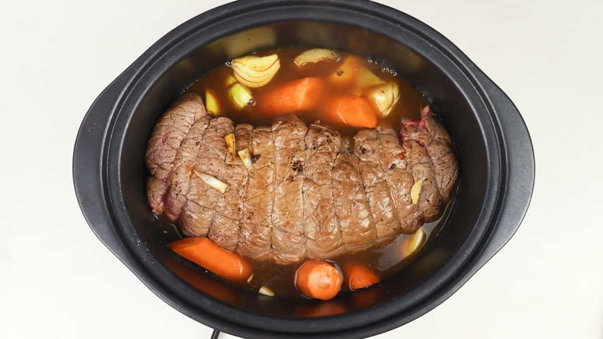 Slow cooker with beef joint and vegetables