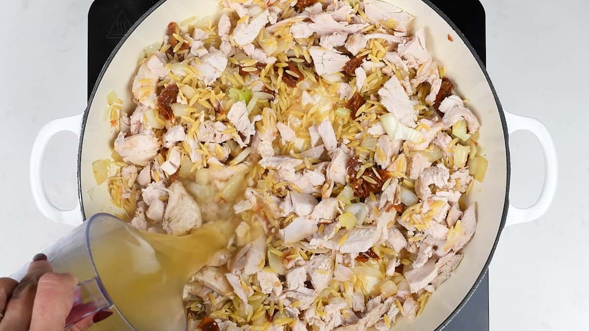Adding chicken stock to make orzo pasta recipe