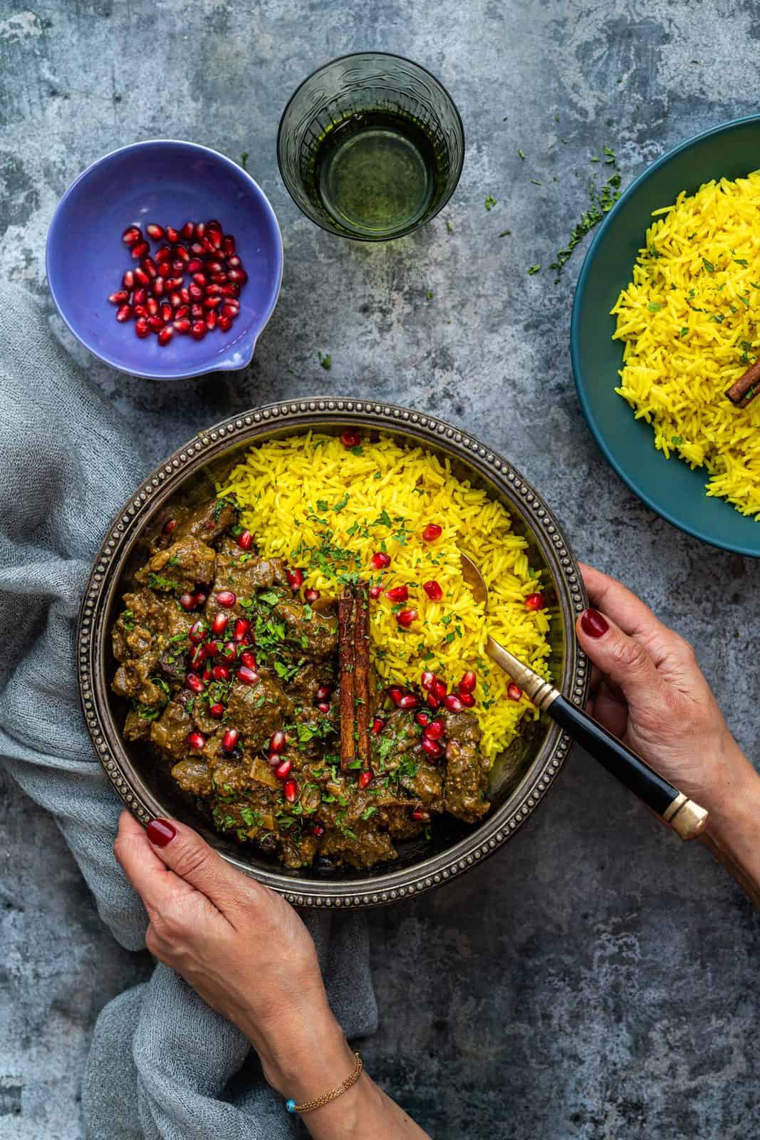 Pilau rice served with lamb stew and garnished with pomegranate seeds