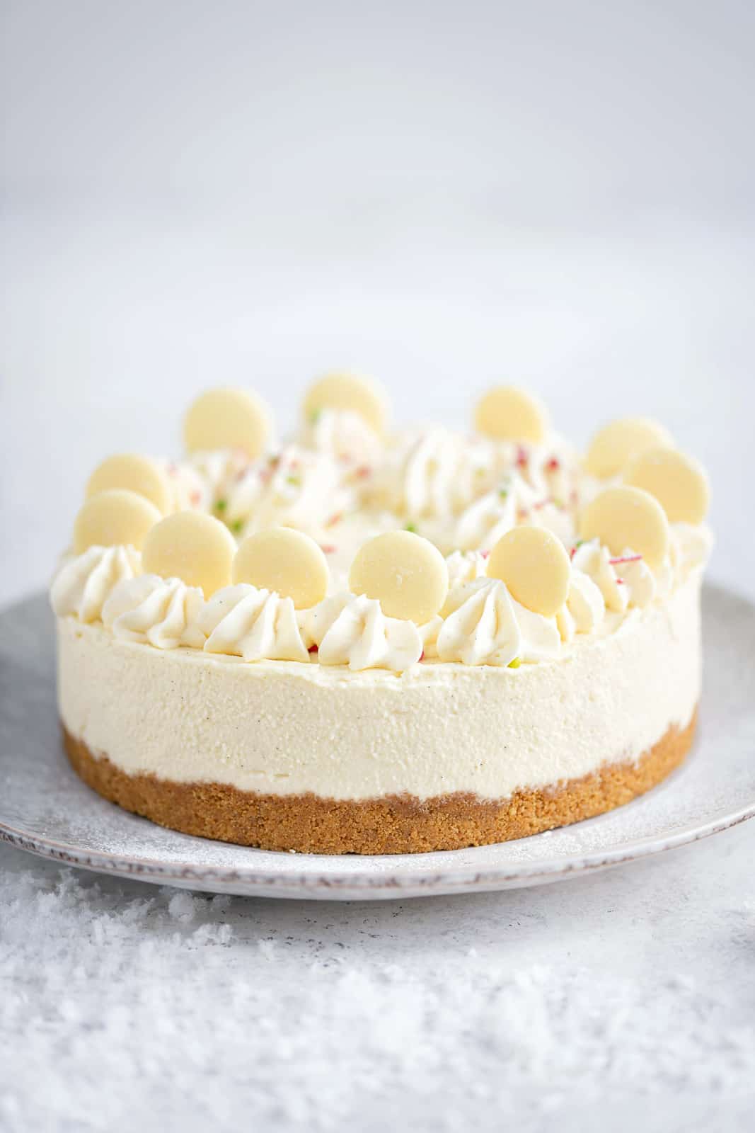 White chocolate cheesecake with piped cream and white chocolate buttons