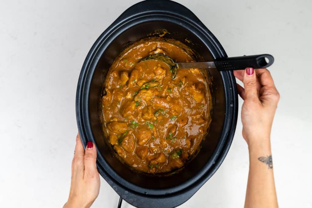 Chicken curry in a slow cooker garnished with coriander