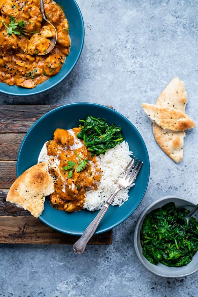Serving of slimming world slow cooker chicken curry with rice, naan bread and steam spinach