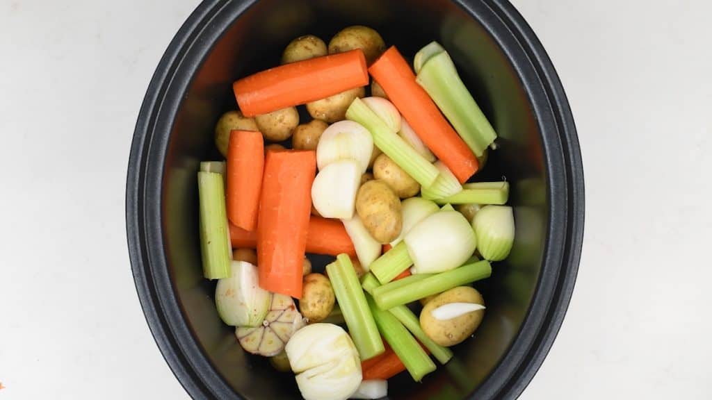 Carrots, onions, celery and potatoes in a slow cooker
