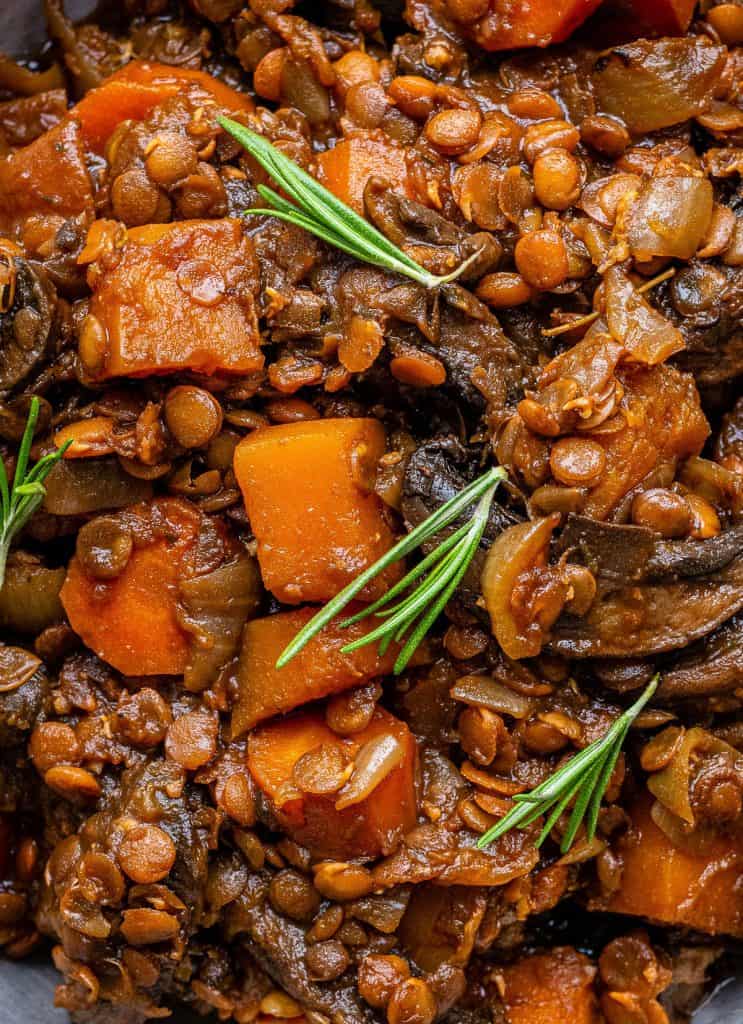 Close up on vegan stew with mushrooms lentils, carrots and squash