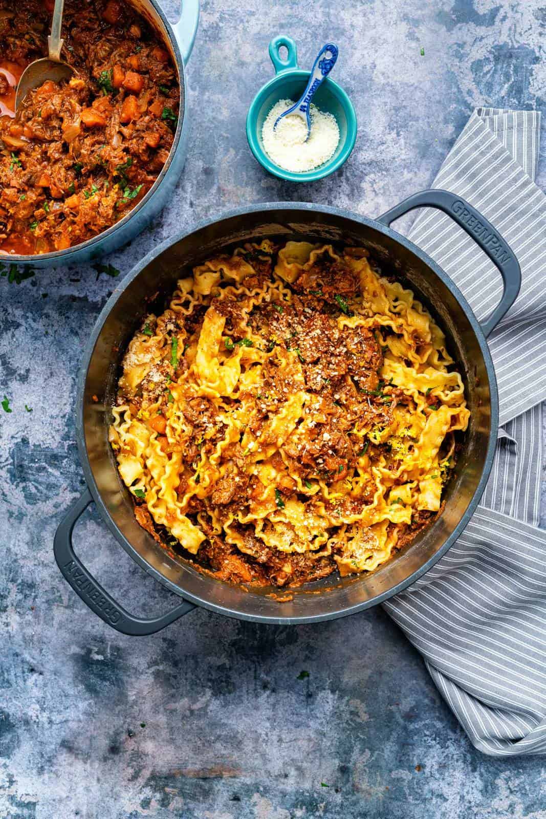 Pot of mafaldine pasta tossed with rich meaty ragu sauce