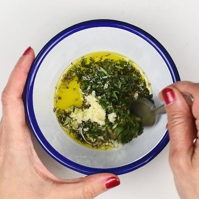 Making garlic and herb marinade in a bowl