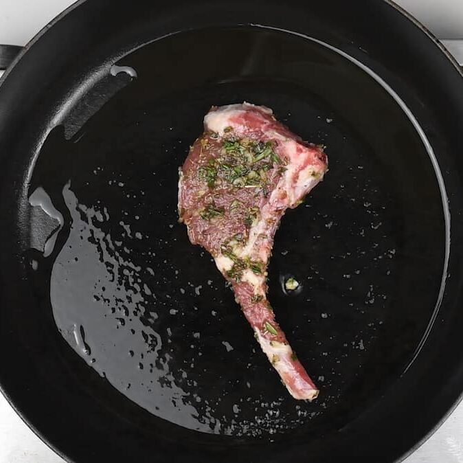 Pan frying lamb chop in a skillet