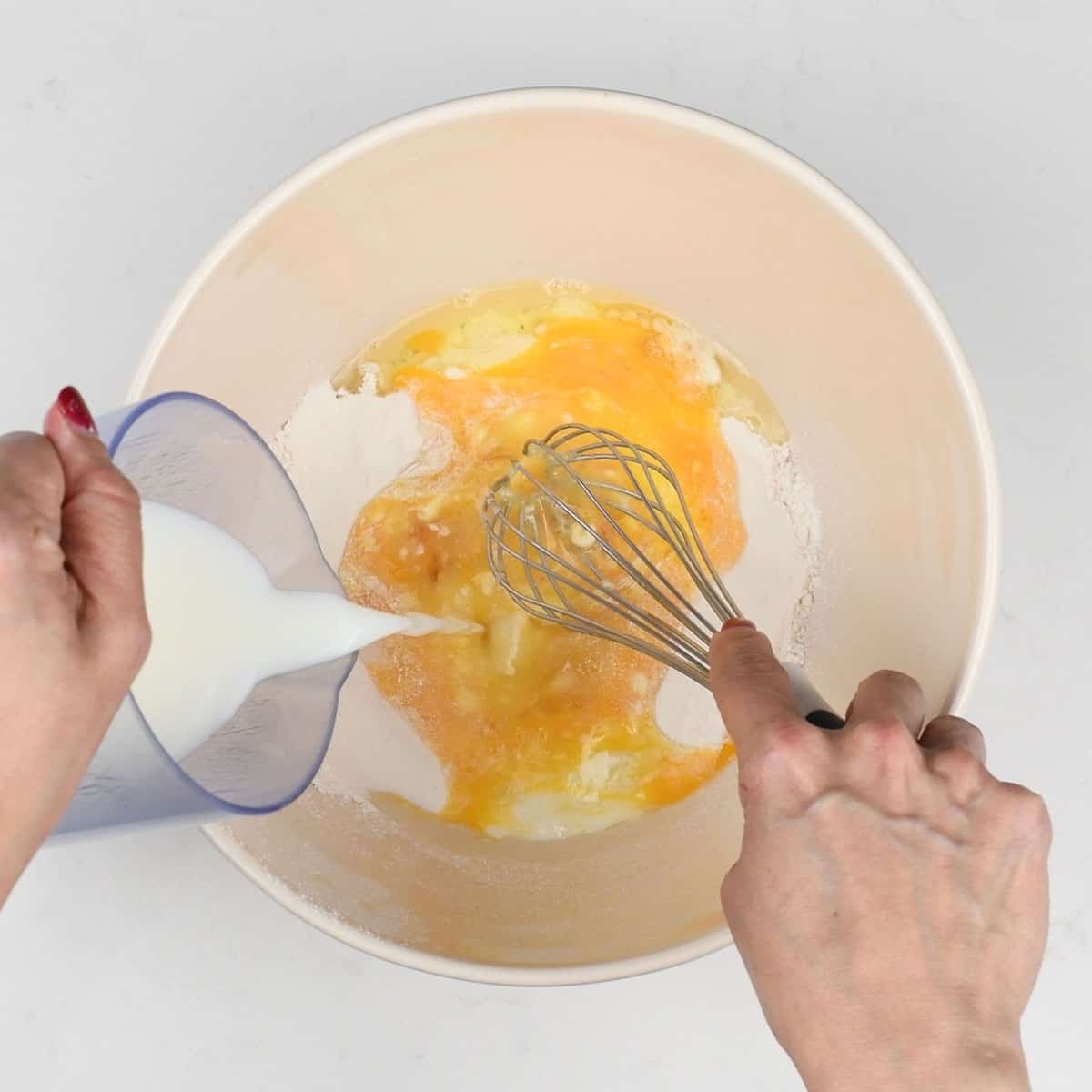 Mixing flour eggs and milk to make pancake batter in a bowl
