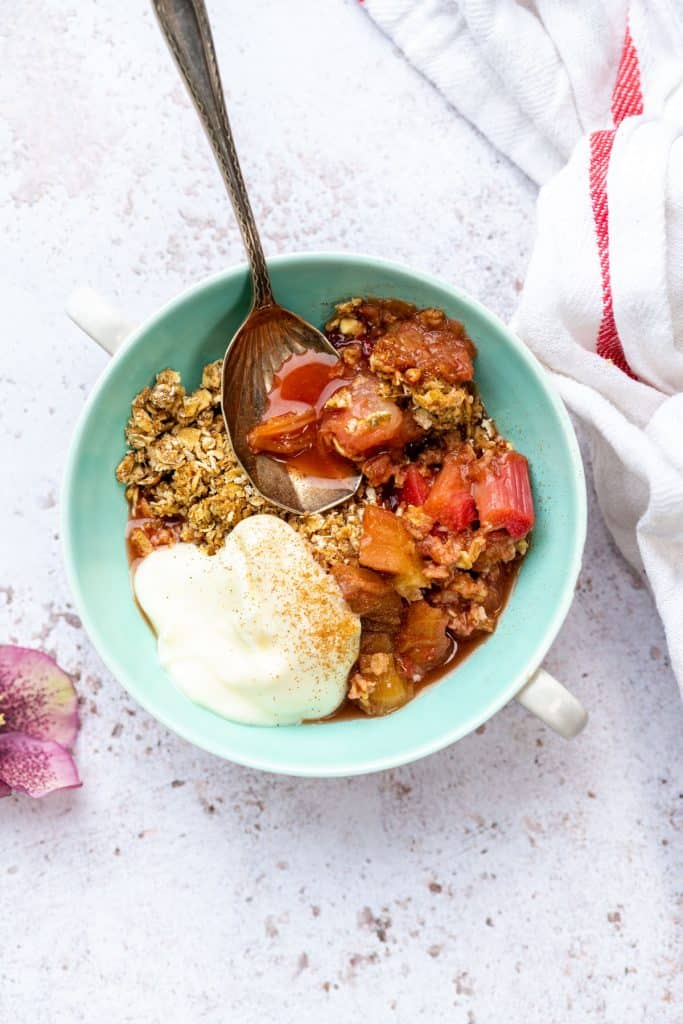 Slimming World rhubarb crumble served in a bowl with yoghurt