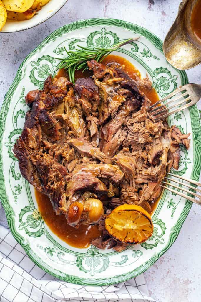 Pulled leg of lamb on a platter with gravy