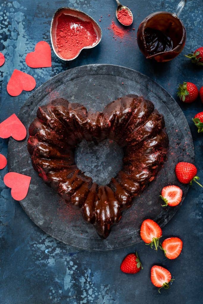 Heart shaped chocolate bundt cake with chocolate glaze on a marble board