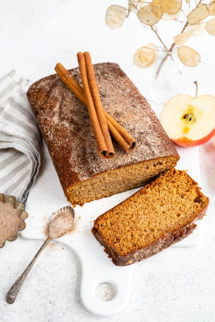 Apple loaf decorated with cinnamon stick with a slice cut 