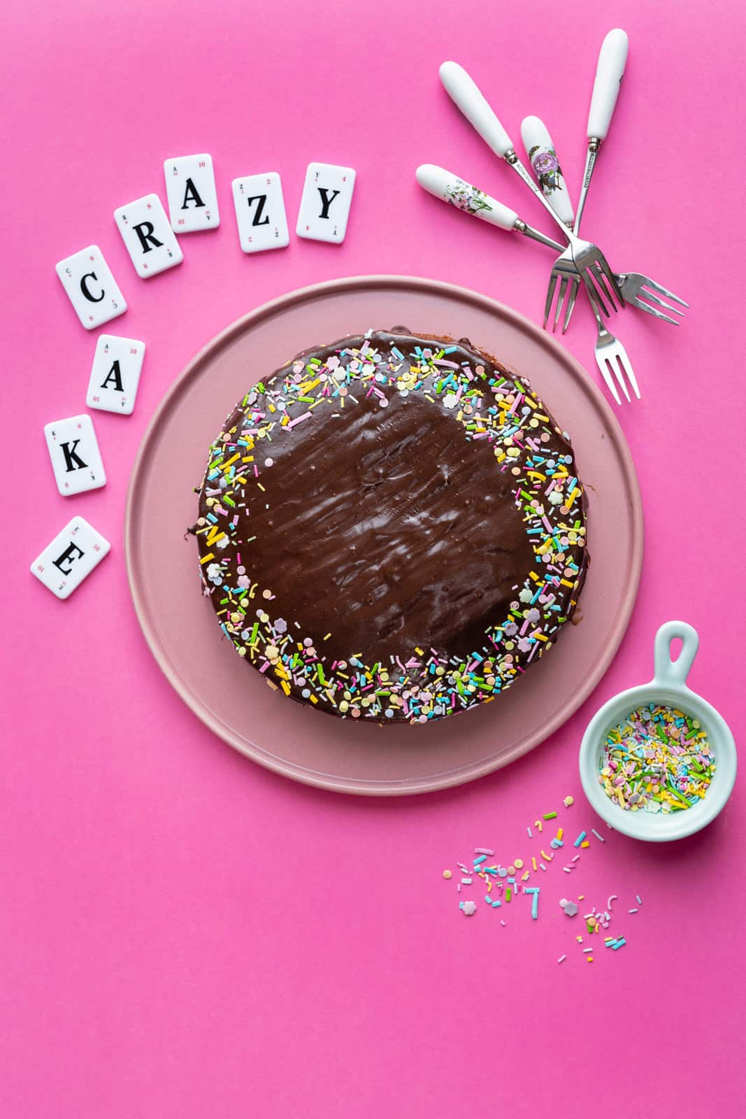 Chocolate crazy cake covered with chocolate glaze and decorated with colourful sprinkles
