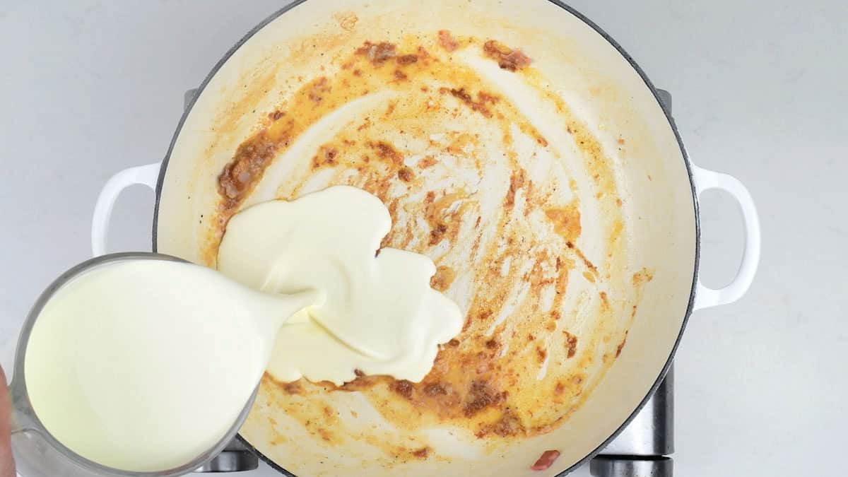adding cream to a pan