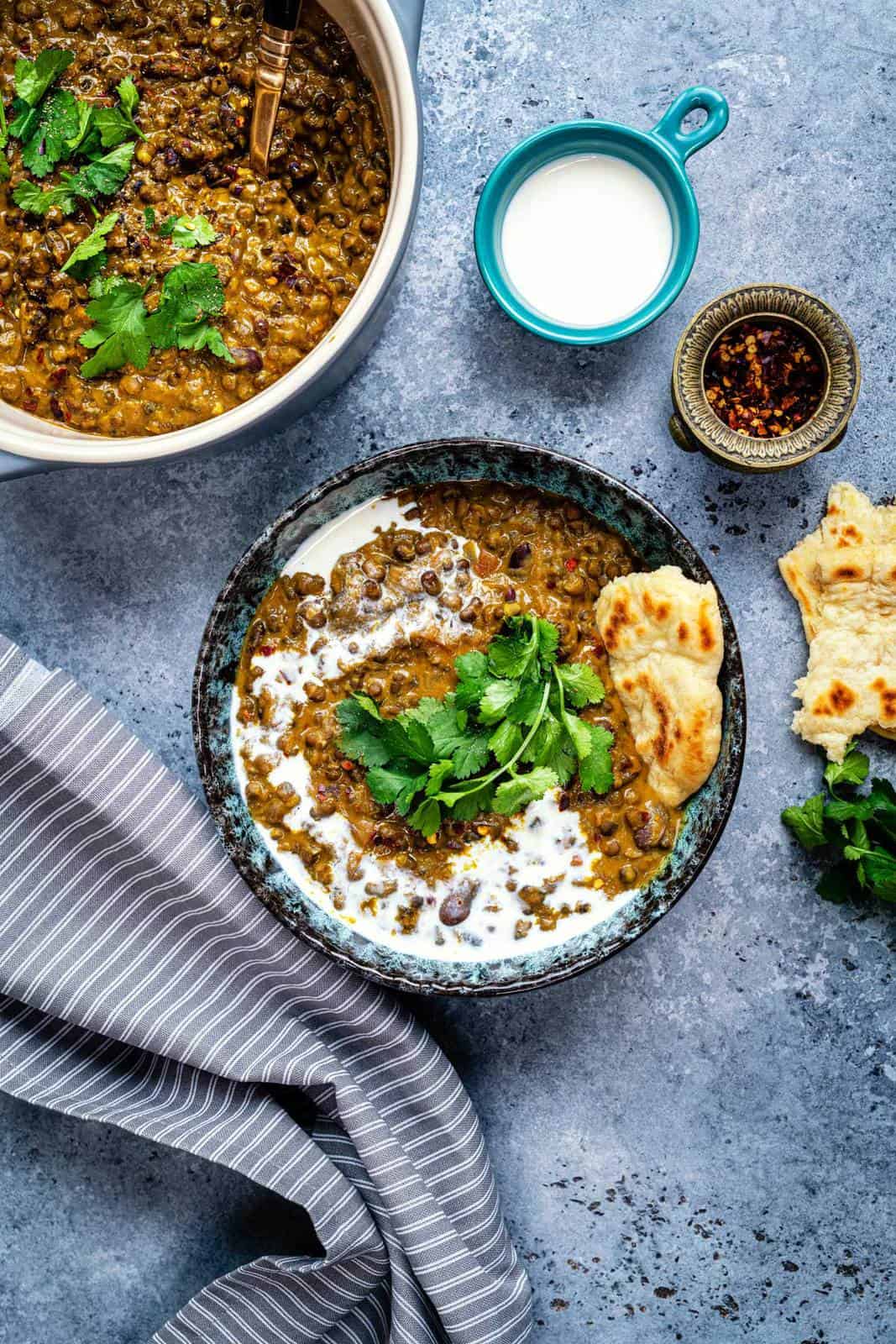 Bowl of Dal Makhani garnished with coriander and a drizzle or soya cream