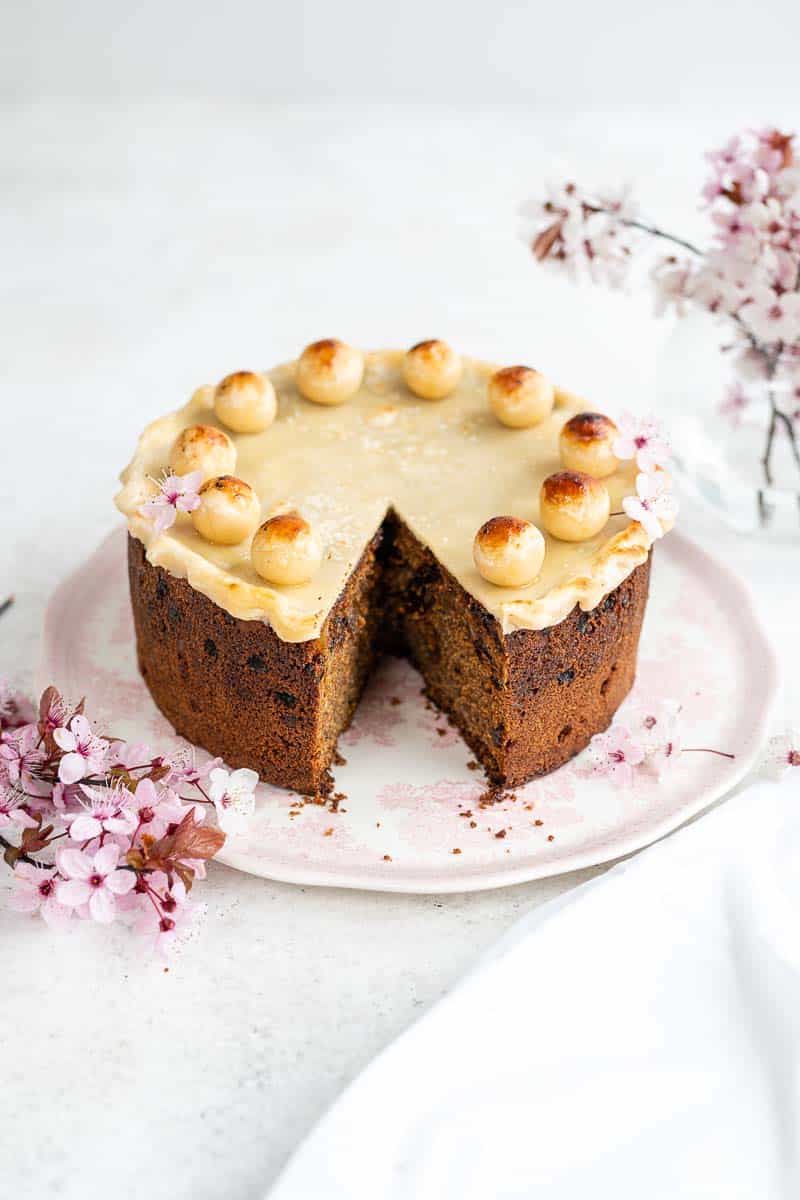 Easter Simnel Cake with slice taken out on pink platter 