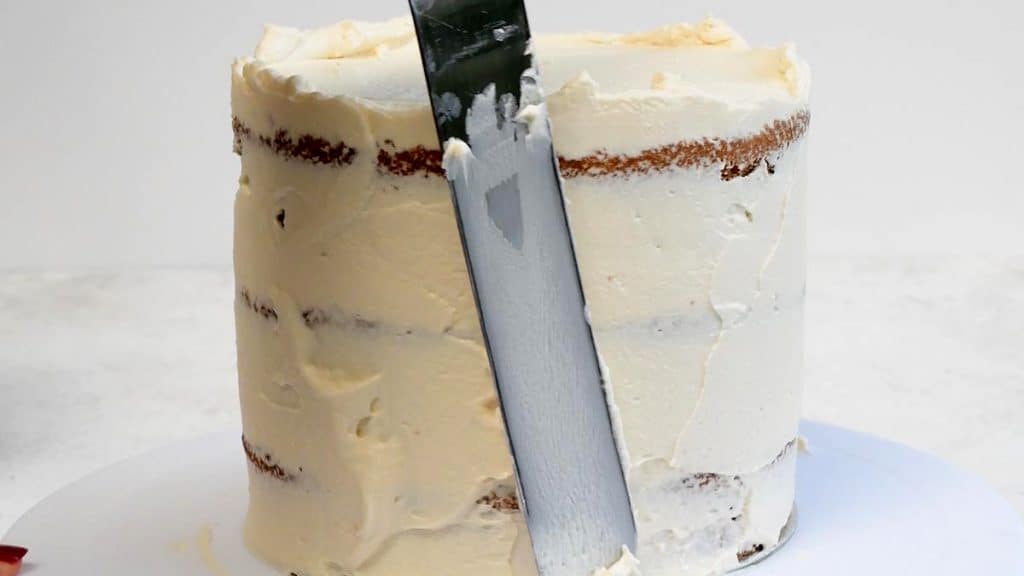Smoothing frosting on layer cake with offset spatula