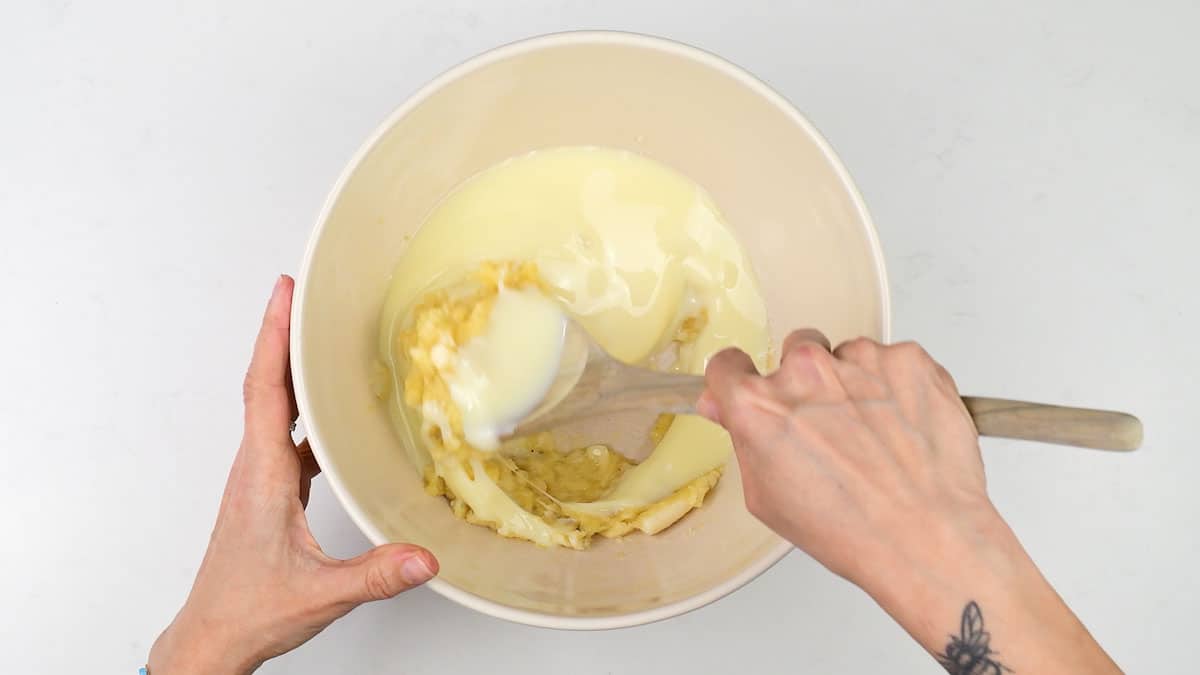 Mixing mashed bananas and sweetened condensed milk in a bowl