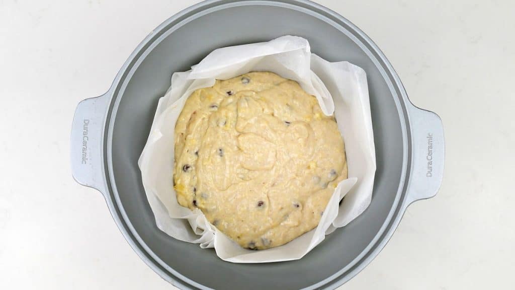 Banana bread in a slow cooker lined with baking paper.