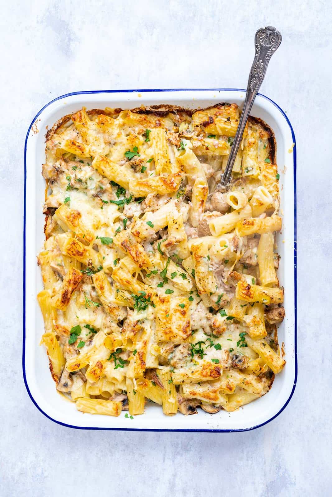 Cheesy tuna paste bake in a roasting dish garnished with chopped parsley