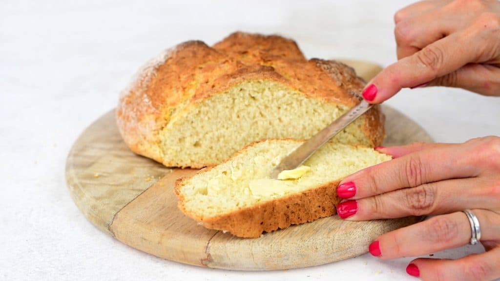 Spreading a slice of no yeast bread with butter