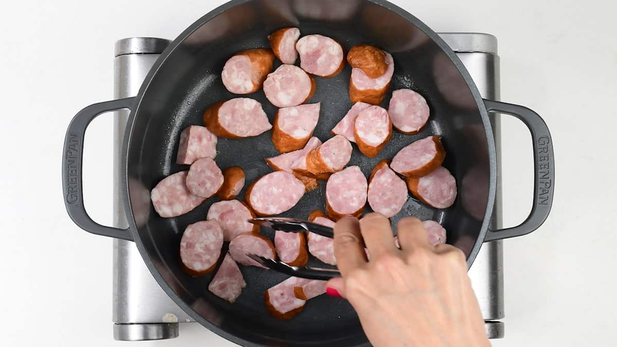 pan frying sausages in a pot