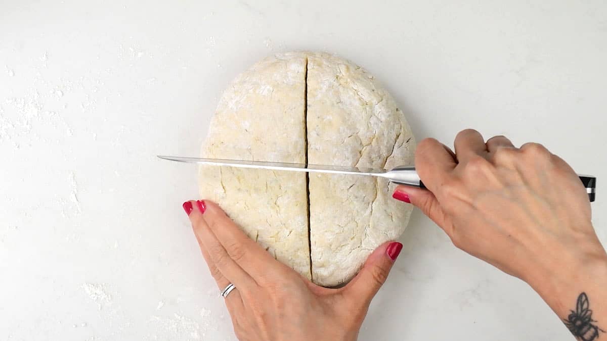 Cutting a cross on top of round shaped loaf