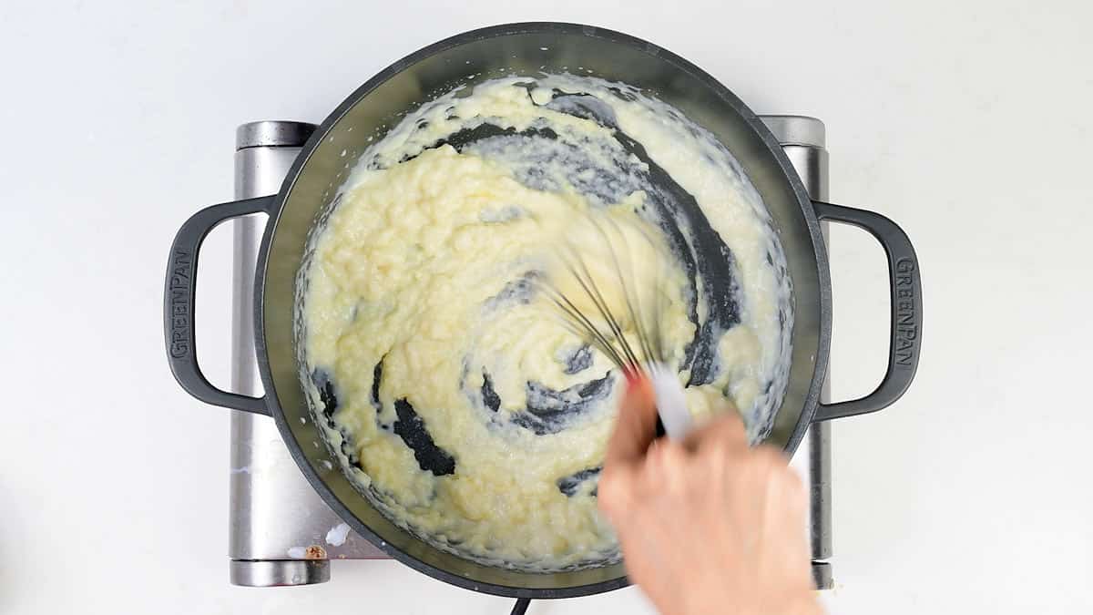 making a white sauce with flour, butter and milk in a pot