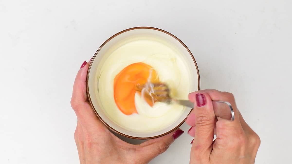 mixing cream and egg in a bowl