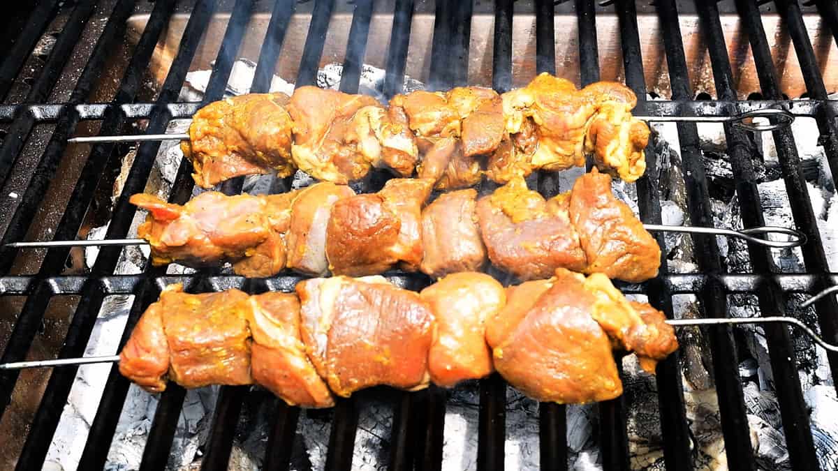 cook lamb skewers over charcoal barbecue