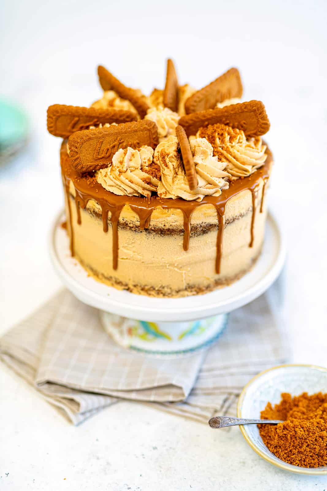 Biscoff Cake on a cake stand decorated with Lotus Biscoff biscuits