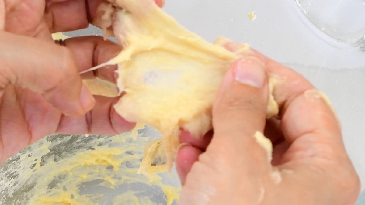 stretching dough between fingers to  check whether it is ready