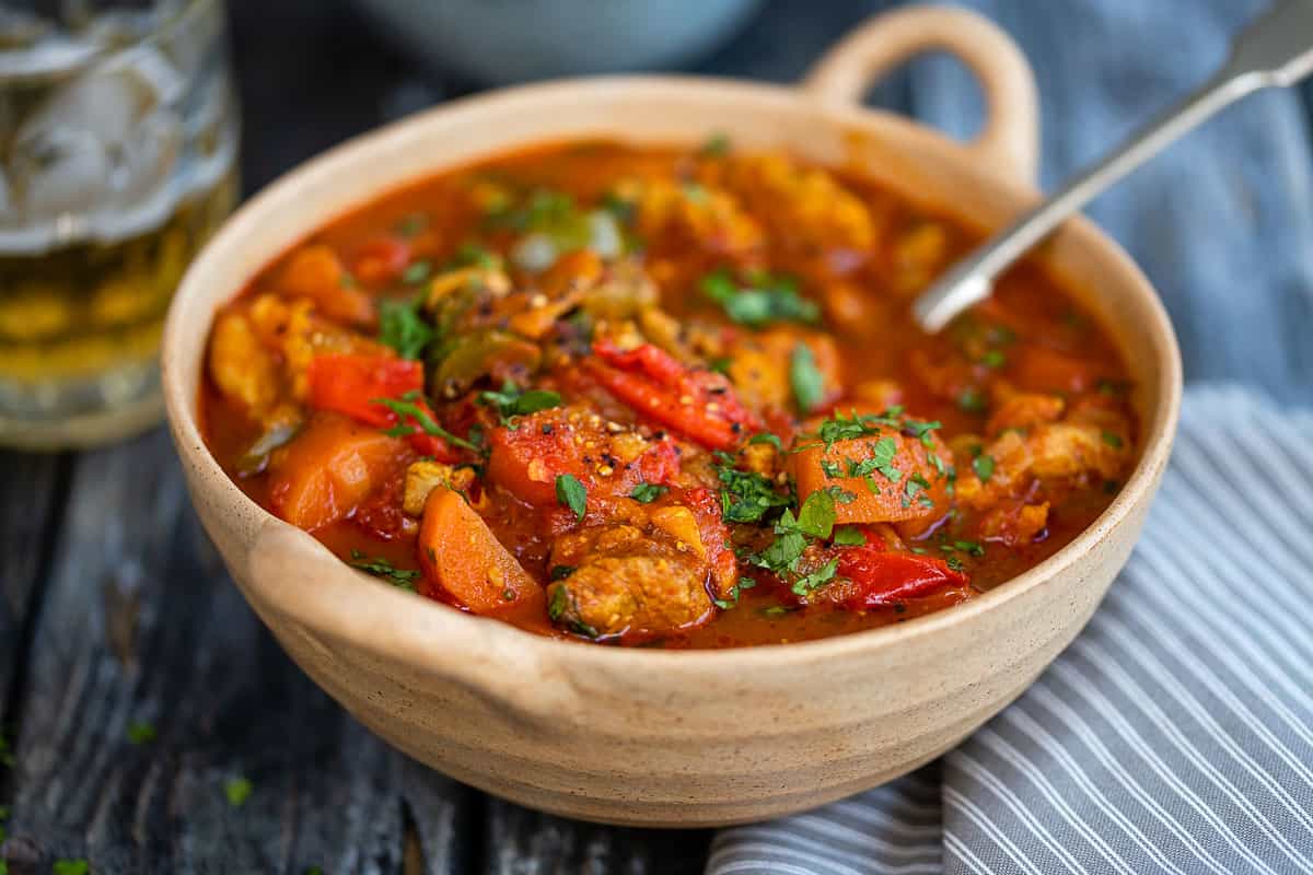 healthy chicken curry in a ceramic bowl garnished with coriander