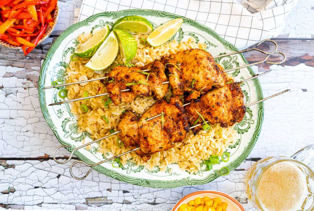 Peri Peri chicken thigh skewers served over rice on a patterned platter
